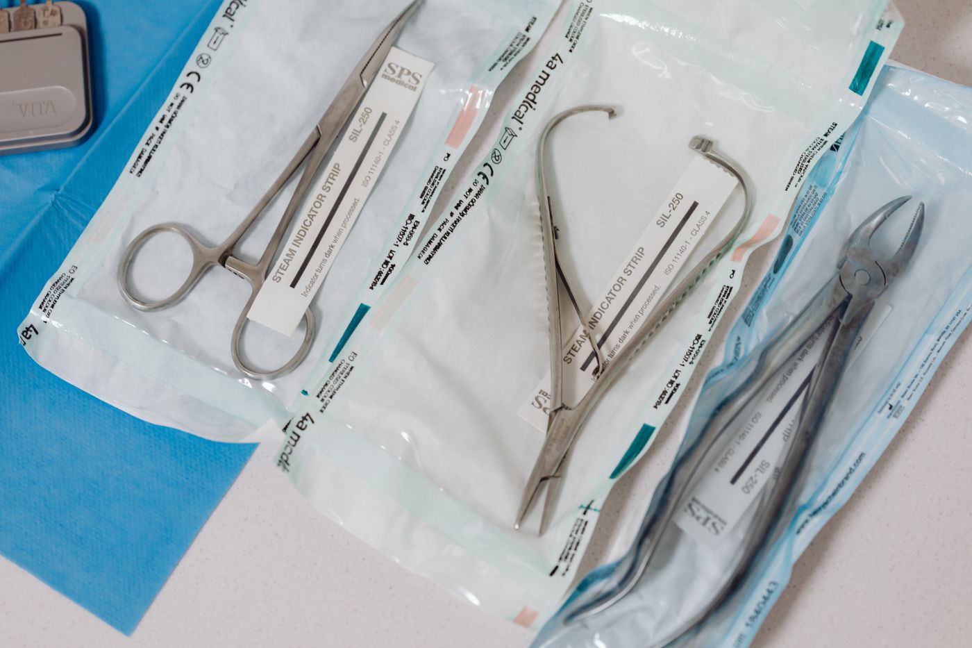 Surgical instruments in sterilization pouches with steam indicator strips